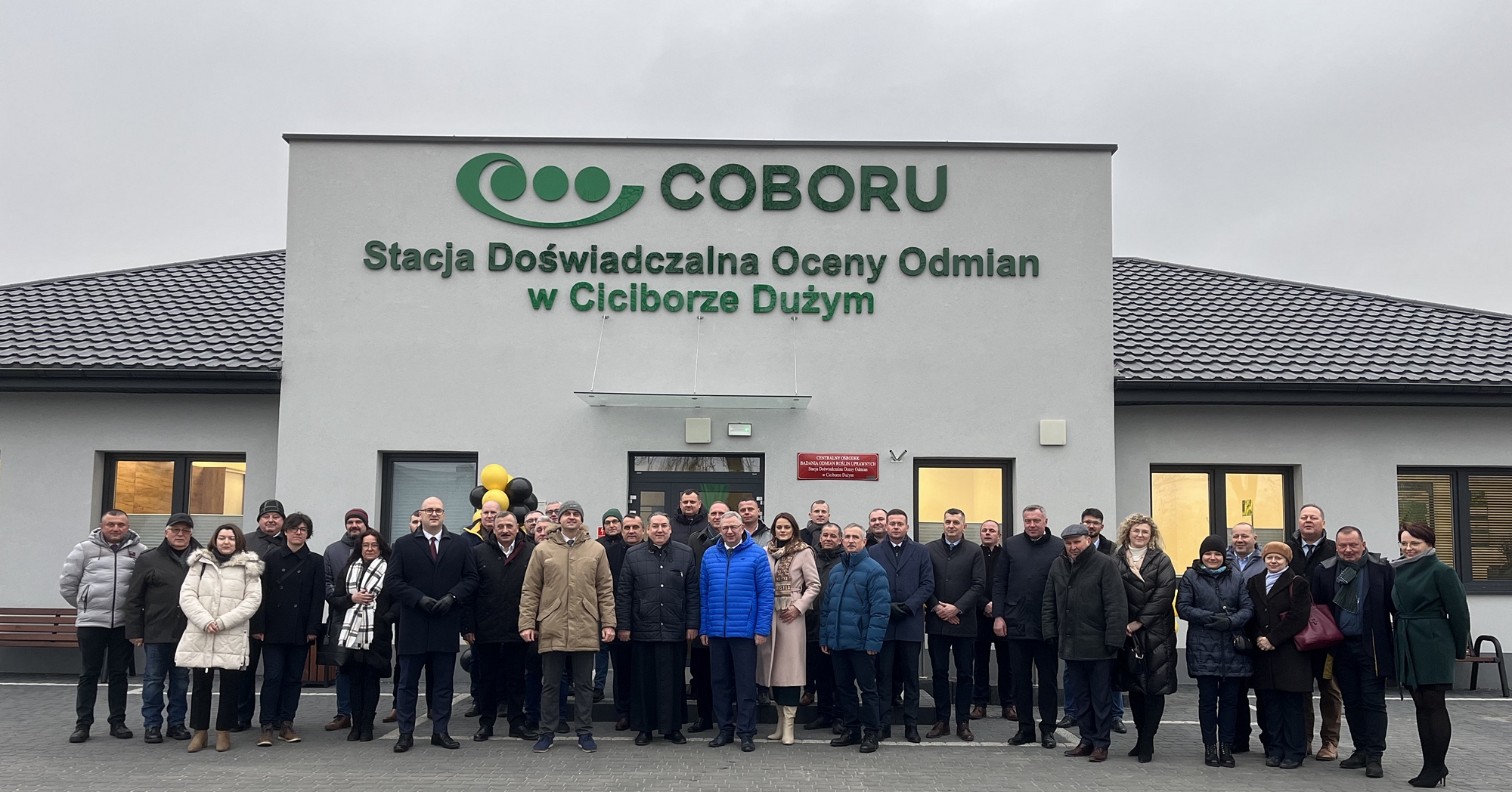 Wspólne zdjęcie uczestników otwarcia siedziby przed nowym budynkiem SDOO w Ciciborze Dużym
